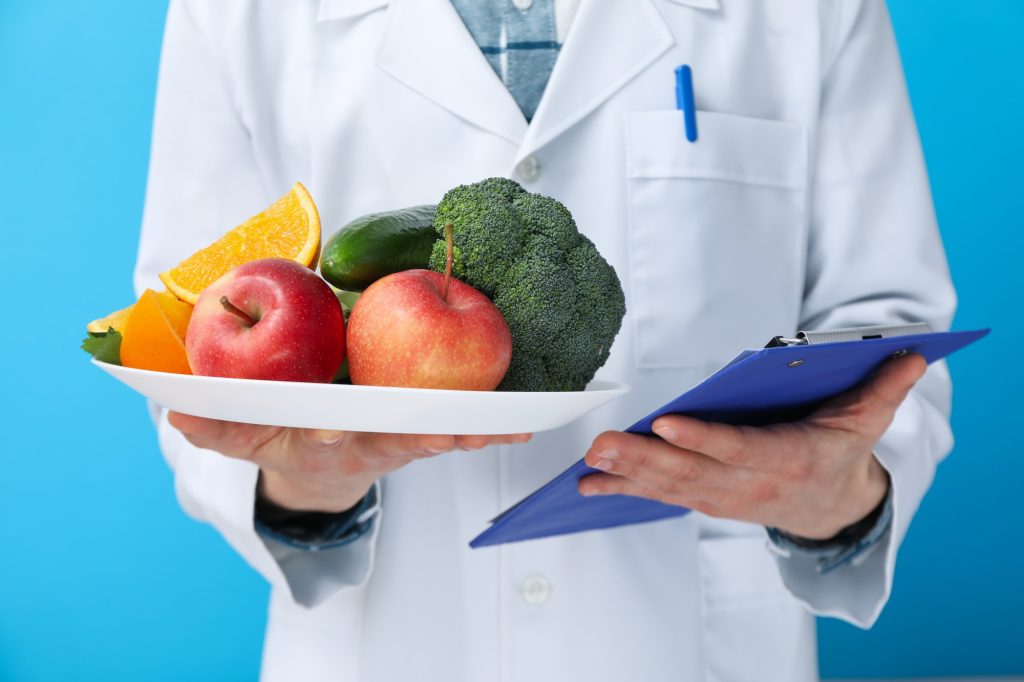 Doctor with healthy food and clipboard - healthy nutrition concept